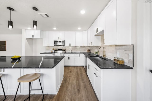 2003 Carriage Club Dr, Cedar Park, TX 78613 - kitchen with appliances with stainless steel finishes, dark wood-style flooring, decorative backsplash, white cabinetry, and recessed lighting