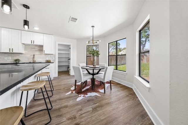 2003 Carriage Club Dr, Cedar Park, TX 78613 - dining room featuring baseboards, wood finished floors, and a chandelier