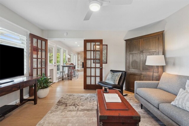 8900 Rockcrest Dr, Austin, TX 78759 - living room with french doors, light wood-style floors, ceiling fan, and a desk