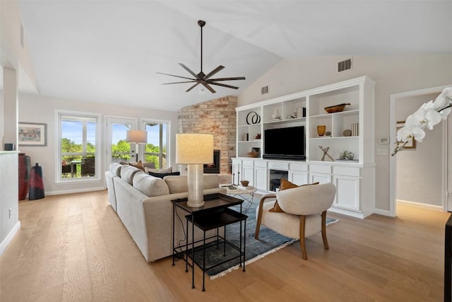 8900 Rockcrest Dr, Austin, TX 78759 - living area with a fireplace, light wood-style floors, lofted ceiling, a ceiling fan, and baseboards