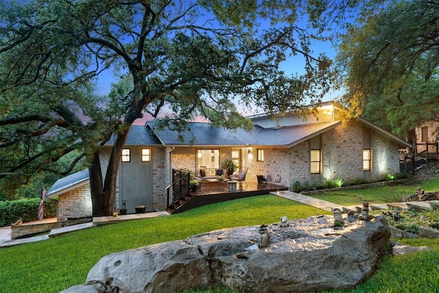 8900 Rockcrest Dr, Austin, TX 78759 - view of front of house with a front lawn, a wooden deck, and stone siding