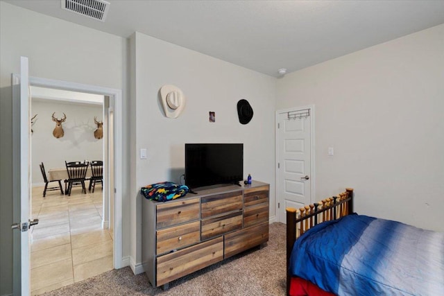 bedroom featuring light tile patterned floors, light colored carpet, and baseboards