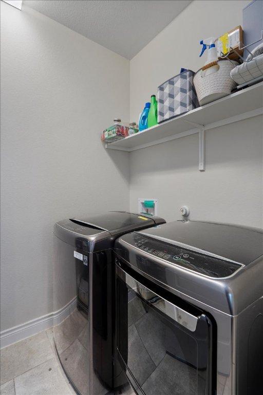 laundry room with washing machine and dryer and baseboards