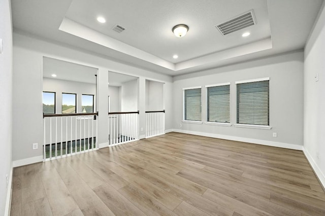 16708 Rakesh Way, Manor, TX 78653 - unfurnished room with a tray ceiling, wood finished floors, baseboards, and recessed lighting