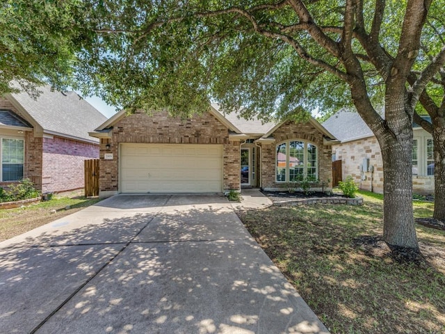 view of front of house with brick siding, an attached garage, concrete driveway, and fence