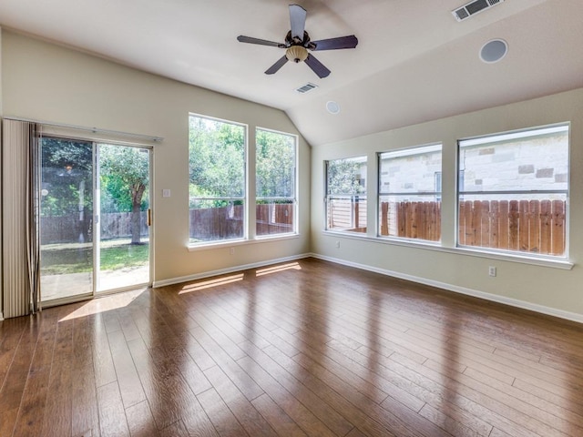 empty room featuring ceiling fan, dark wood-style flooring, baseboards, and vaulted ceiling
