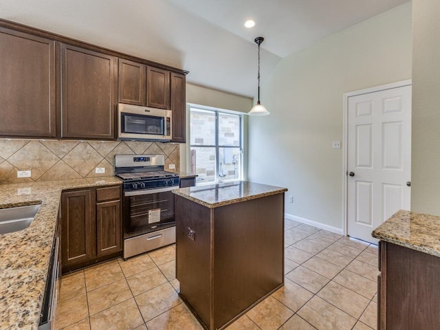 kitchen with appliances with stainless steel finishes, light tile patterned flooring, lofted ceiling, dark brown cabinetry, and backsplash