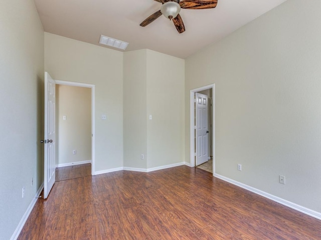 spare room with ceiling fan, wood finished floors, and baseboards