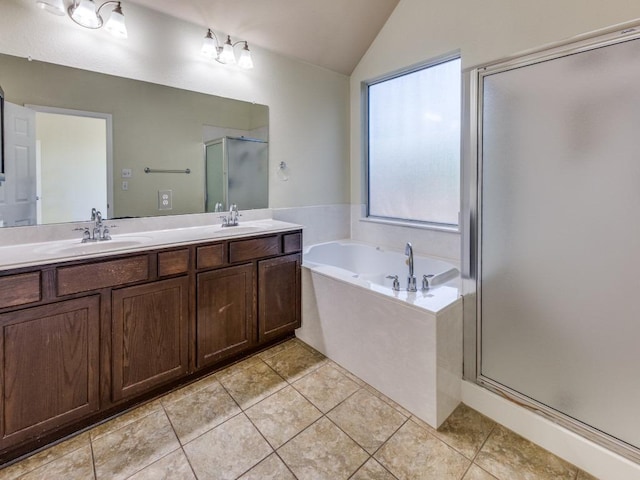 bathroom featuring lofted ceiling, a shower stall, a bath, double vanity, and tile patterned flooring
