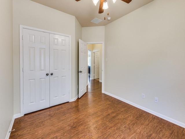 unfurnished bedroom featuring wood finished floors, baseboards, a closet, and a ceiling fan