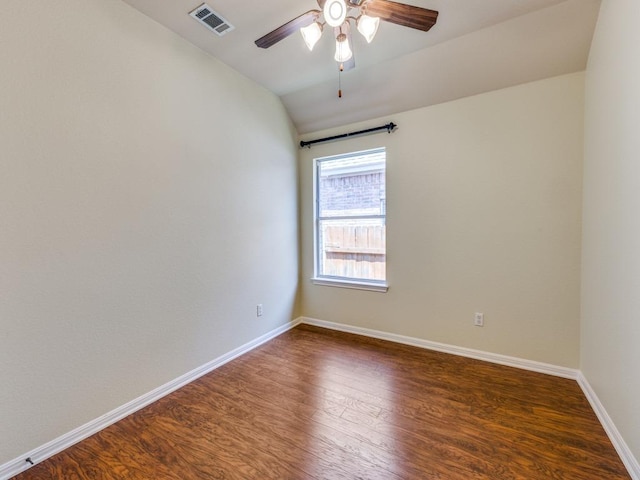 spare room featuring dark wood finished floors, lofted ceiling, baseboards, and a ceiling fan