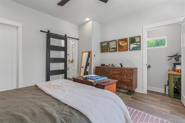 5308 Evans Ave Unit 2, Austin, TX 78751 - bedroom with a barn door, wood finished floors, baseboards, recessed lighting, and a ceiling fan