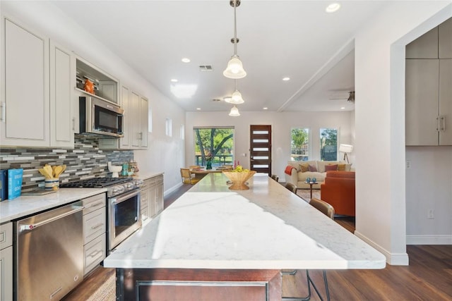 906 Linden St Unit A, Austin, TX 78702 - kitchen with appliances with stainless steel finishes, wood finished floors, a center island, healthy amount of natural light, and recessed lighting