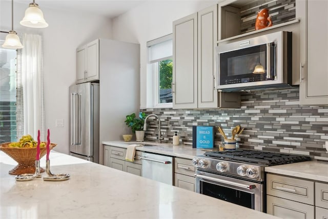 906 Linden St Unit A, Austin, TX 78702 - kitchen with appliances with stainless steel finishes, decorative backsplash, light stone counters, pendant lighting, and a sink