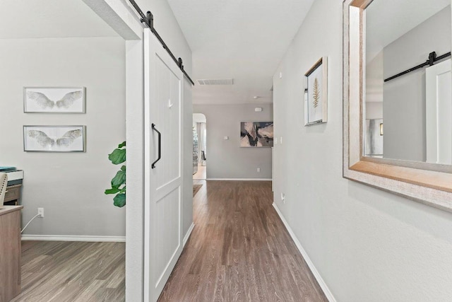 1116 Brenham Ln, Leander, TX 78641 - hallway with a barn door, wood finished floors, and baseboards