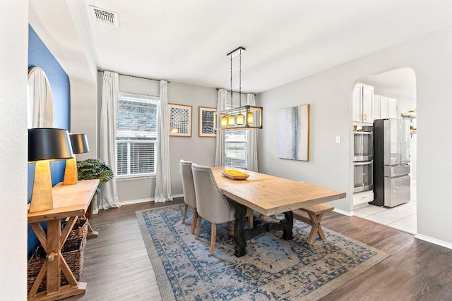 1116 Brenham Ln, Leander, TX 78641 - dining space featuring arched walkways, light wood-type flooring, and baseboards