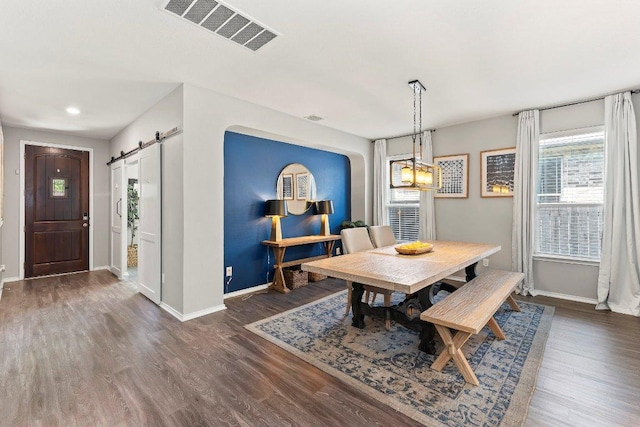 1116 Brenham Ln, Leander, TX 78641 - dining area featuring a barn door, dark wood-style floors, and recessed lighting
