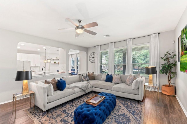 1116 Brenham Ln, Leander, TX 78641 - living area with baseboards, arched walkways, a ceiling fan, and wood finished floors