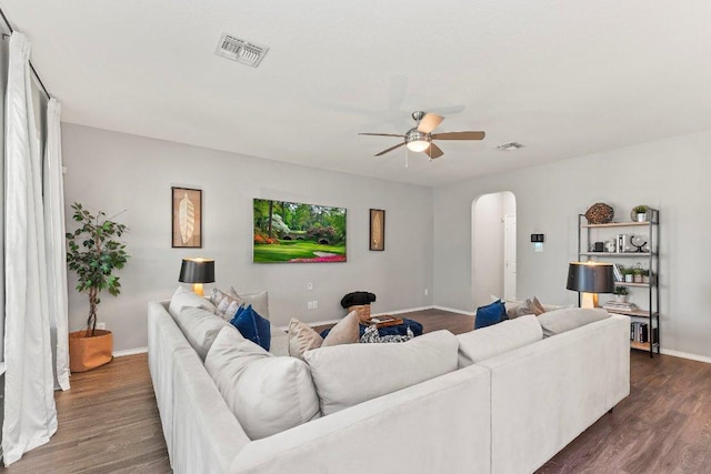 1116 Brenham Ln, Leander, TX 78641 - living room with arched walkways, ceiling fan, dark wood-style floors, and baseboards