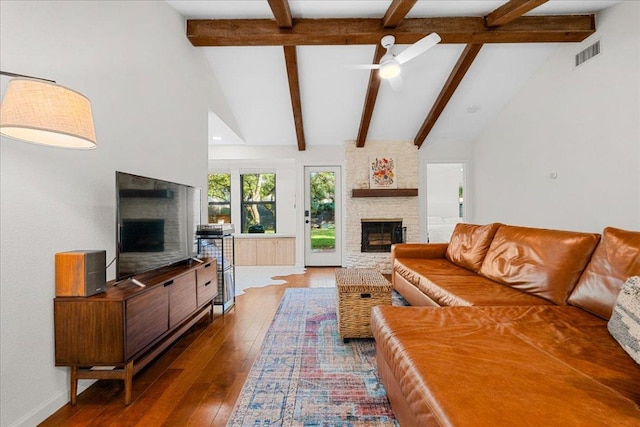 6905 Whispering Oaks Dr, Austin, TX 78745 - living room featuring a stone fireplace, beamed ceiling, hardwood / wood-style floors, a ceiling fan, and baseboards