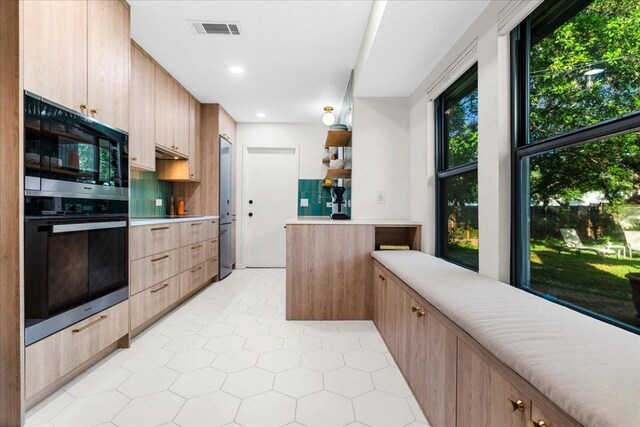 6905 Whispering Oaks Dr, Austin, TX 78745 - kitchen with light countertops, light brown cabinetry, black appliances, modern cabinets, and recessed lighting