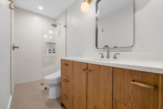 6905 Whispering Oaks Dr, Austin, TX 78745 - bathroom featuring toilet, tiled shower, vanity, and recessed lighting