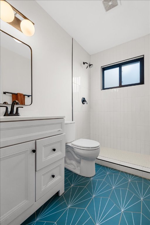 6905 Whispering Oaks Dr, Austin, TX 78745 - full bathroom featuring tiled shower, vanity, toilet, and tile patterned floors