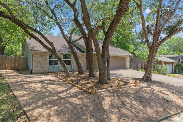 7805 Manassas Dr, Austin, TX 78745 - view of front facade with driveway, stone siding, a garage, and a shingled roof