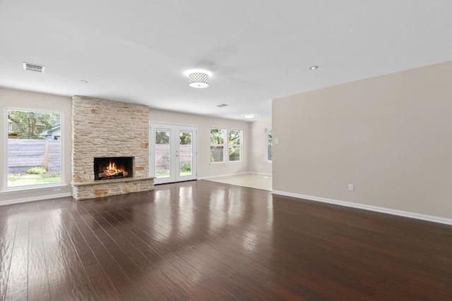 7805 Manassas Dr, Austin, TX 78745 - unfurnished living room featuring a stone fireplace, wood-type flooring, and healthy amount of natural light
