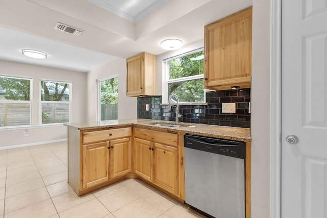 kitchen with stainless steel dishwasher, a sink, a peninsula, decorative backsplash, and light stone counters