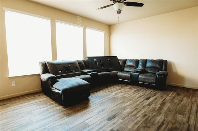 living area featuring a ceiling fan, wood finished floors, and baseboards