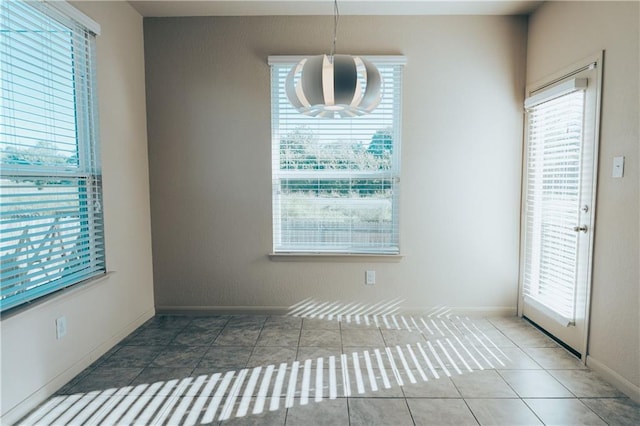 192 Falcon Dr, Luling, TX 78648 - unfurnished dining area with healthy amount of natural light, a chandelier, tile patterned floors, and baseboards