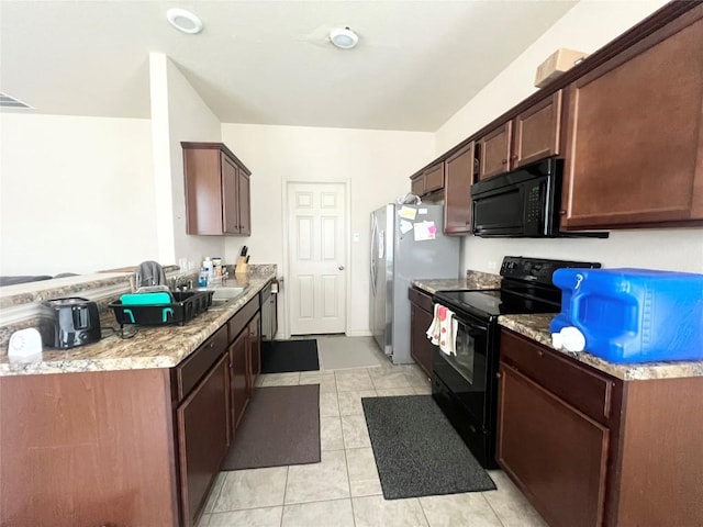 192 Falcon Dr, Luling, TX 78648 - kitchen with black appliances and light tile patterned floors