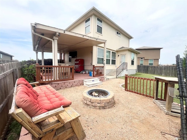 192 Falcon Dr, Luling, TX 78648 - rear view of house with an outdoor fire pit, stucco siding, a fenced backyard, and a patio