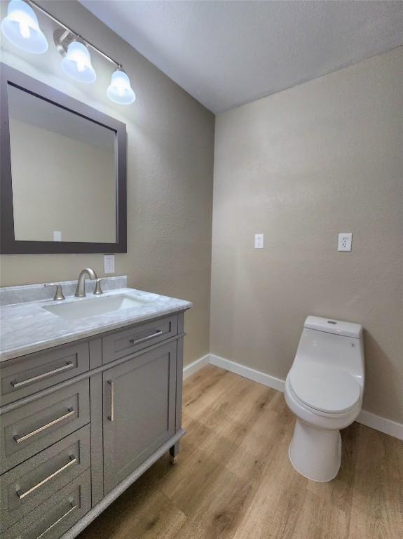 1011 N State Highway 95 N, Bastrop, TX 78602 - bathroom with wood finished floors, baseboards, vanity, and toilet