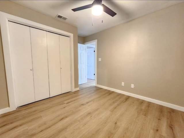 1011 N State Highway 95 N, Bastrop, TX 78602 - unfurnished bedroom featuring baseboards, a closet, light wood finished floors, and a ceiling fan