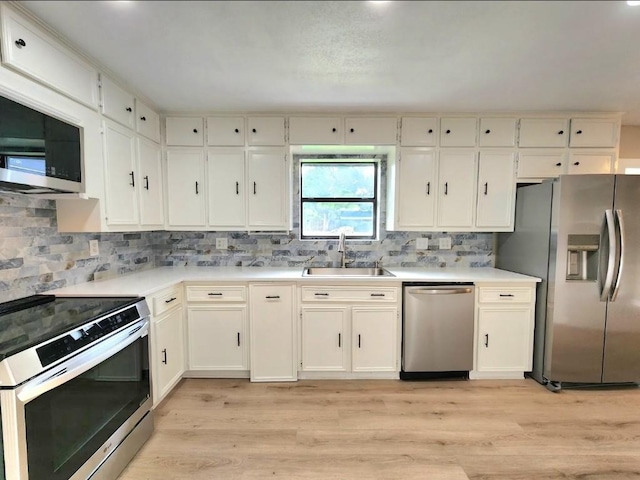 1011 N State Highway 95 N, Bastrop, TX 78602 - kitchen with appliances with stainless steel finishes, a sink, light countertops, decorative backsplash, and light wood finished floors