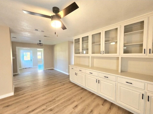 unfurnished room with baseboards, light wood-style floors, and a ceiling fan