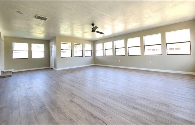 unfurnished living room featuring ceiling fan, wood finished floors, and baseboards