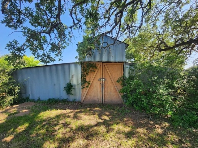 view of outbuilding featuring an outdoor structure and fence