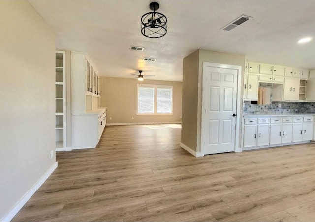 kitchen with open floor plan, baseboards, and light wood-style floors