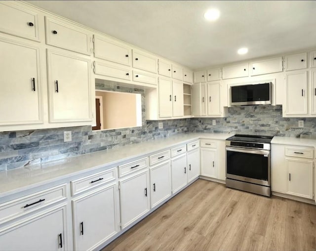 kitchen with appliances with stainless steel finishes, decorative backsplash, light wood-style floors, light countertops, and recessed lighting