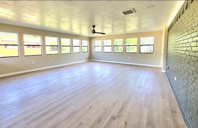 empty room with wood finished floors, baseboards, and a ceiling fan