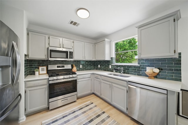605 Swanson Cv, Austin, TX 78748 - kitchen with stainless steel appliances, light wood finished floors, tasteful backsplash, and light countertops