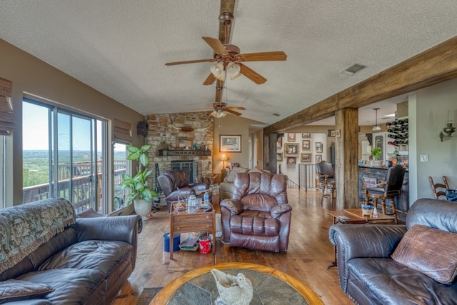 104 Derringer, Horseshoe Bay, TX 78657 - living area with ceiling fan, a textured ceiling, wood finished floors, a fireplace, and vaulted ceiling