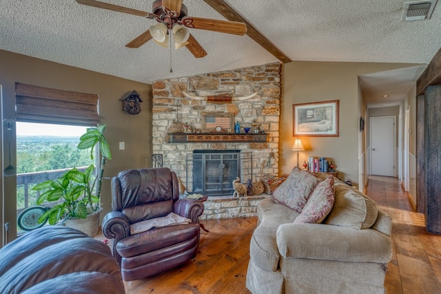 104 Derringer, Horseshoe Bay, TX 78657 - living room featuring a textured ceiling, hardwood / wood-style flooring, ceiling fan, and a stone fireplace