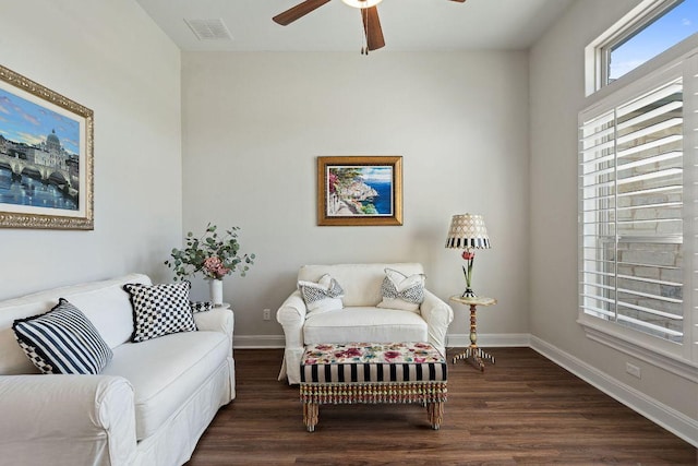 living area featuring a ceiling fan, dark wood-style flooring, and baseboards