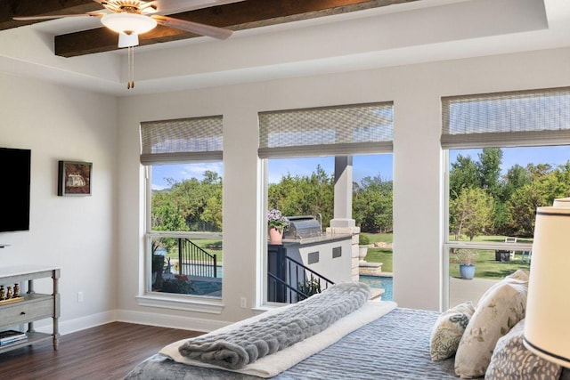bedroom featuring wood finished floors, beam ceiling, multiple windows, baseboards, and access to exterior