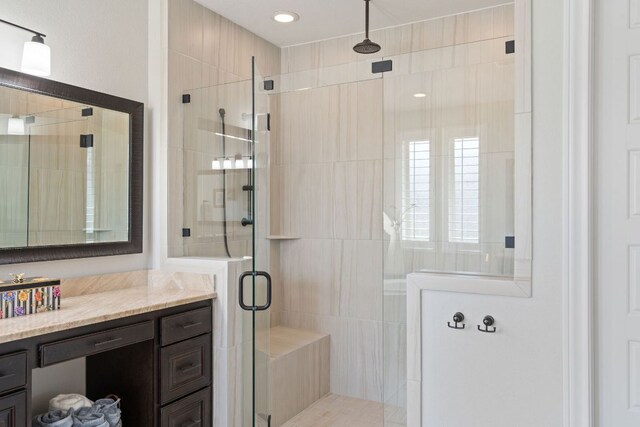 bathroom with a shower stall and vanity