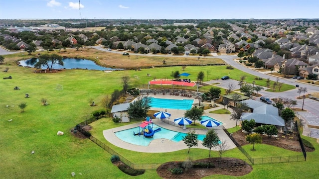 drone / aerial view of a pool area and a nearby body of water